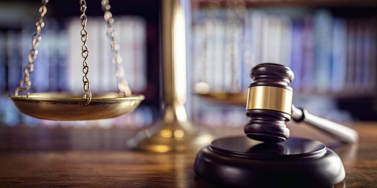 Judge gavel, scales of justice and law books in court